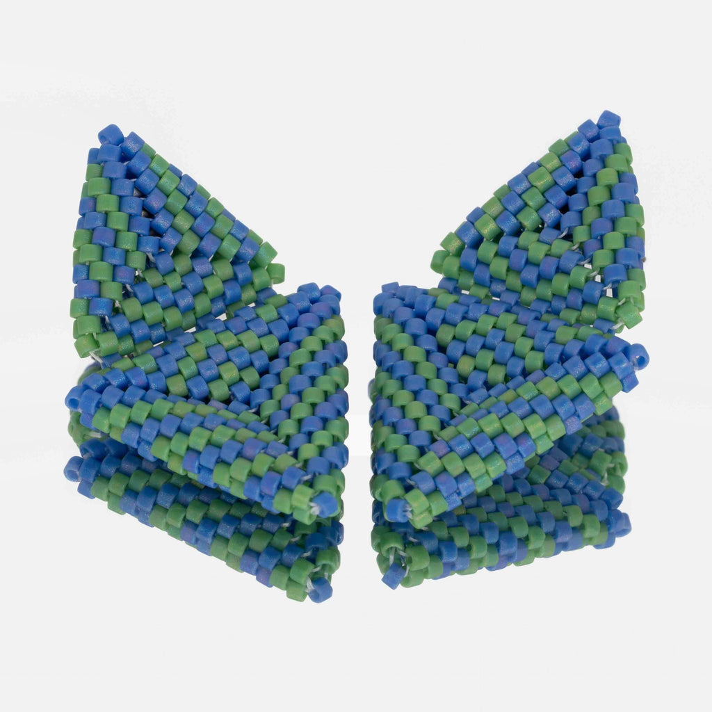 Pair of hand-woven blue and green beaded triangle earrings, standing on a mirror
