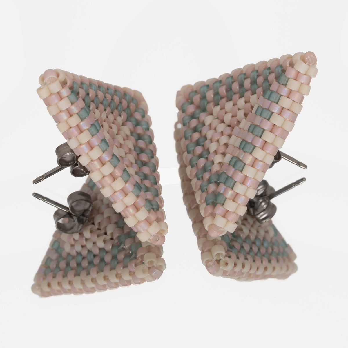 Back of the blush, cream, and seafoam beaded triangle earrings, showing titanium posts and butterfly backs
