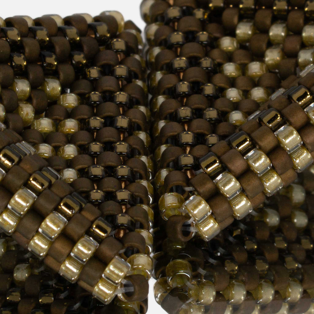 Close-up of matte bronze and gold-lined olive and amber cylinder beads woven in peyote stitch
