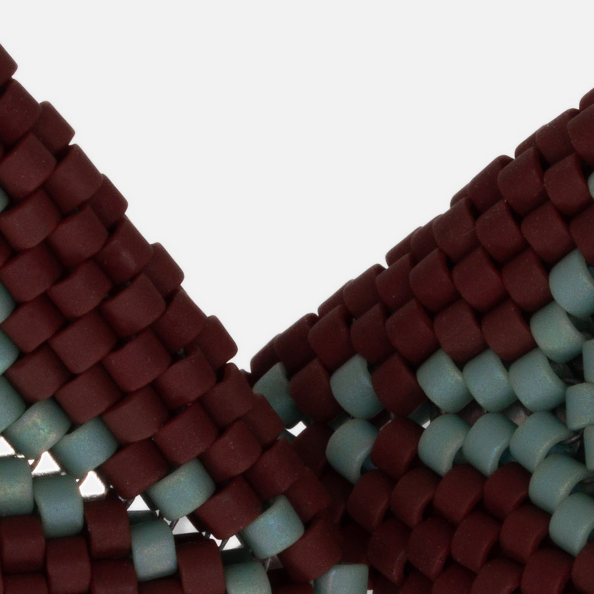 Close-up of matte burgundy and iridescent seafoam cylinder beads woven in peyote stitch