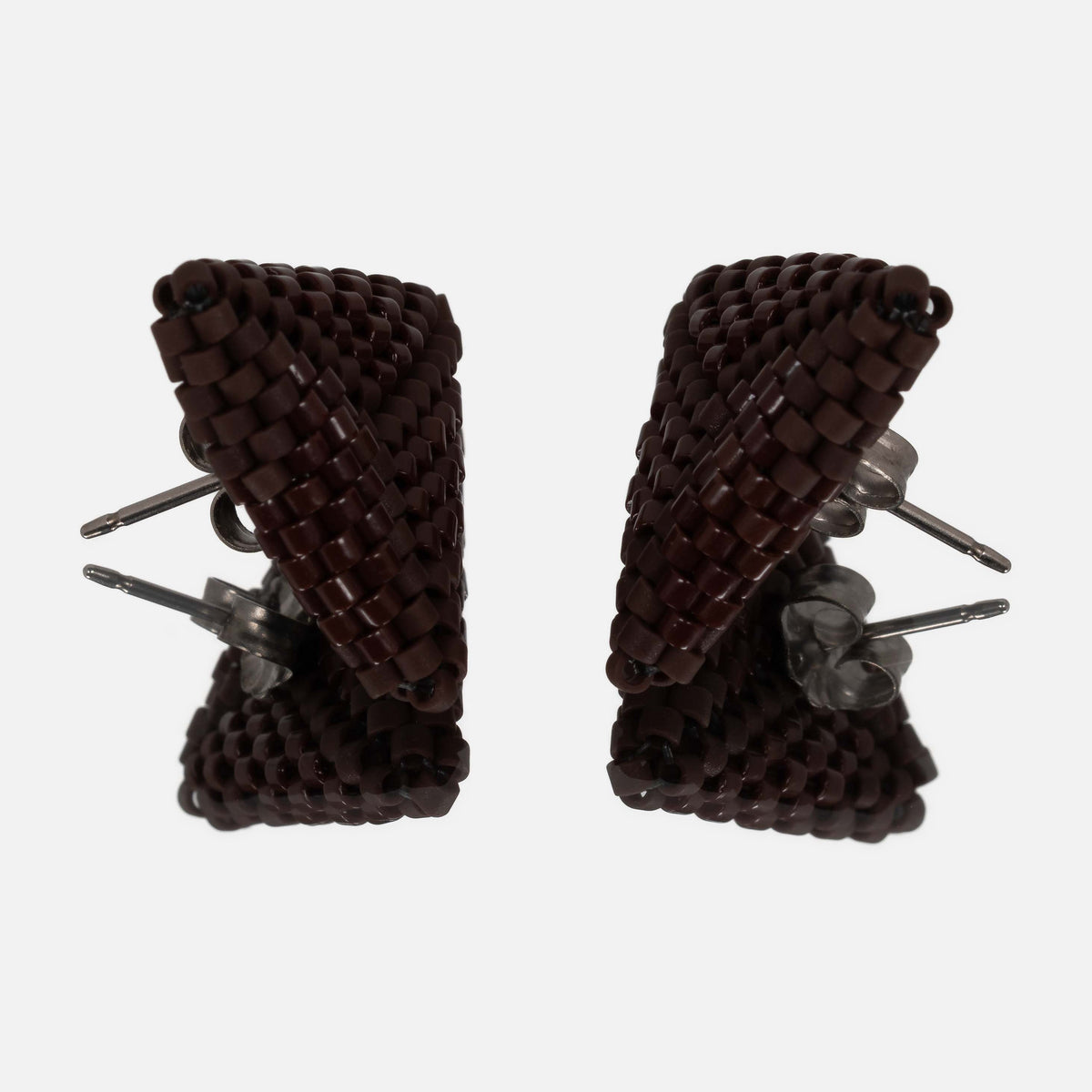 Pair of chocolate brown beaded triangle earrings facing each other on a mirror, showing the titanium posts and the woven edges