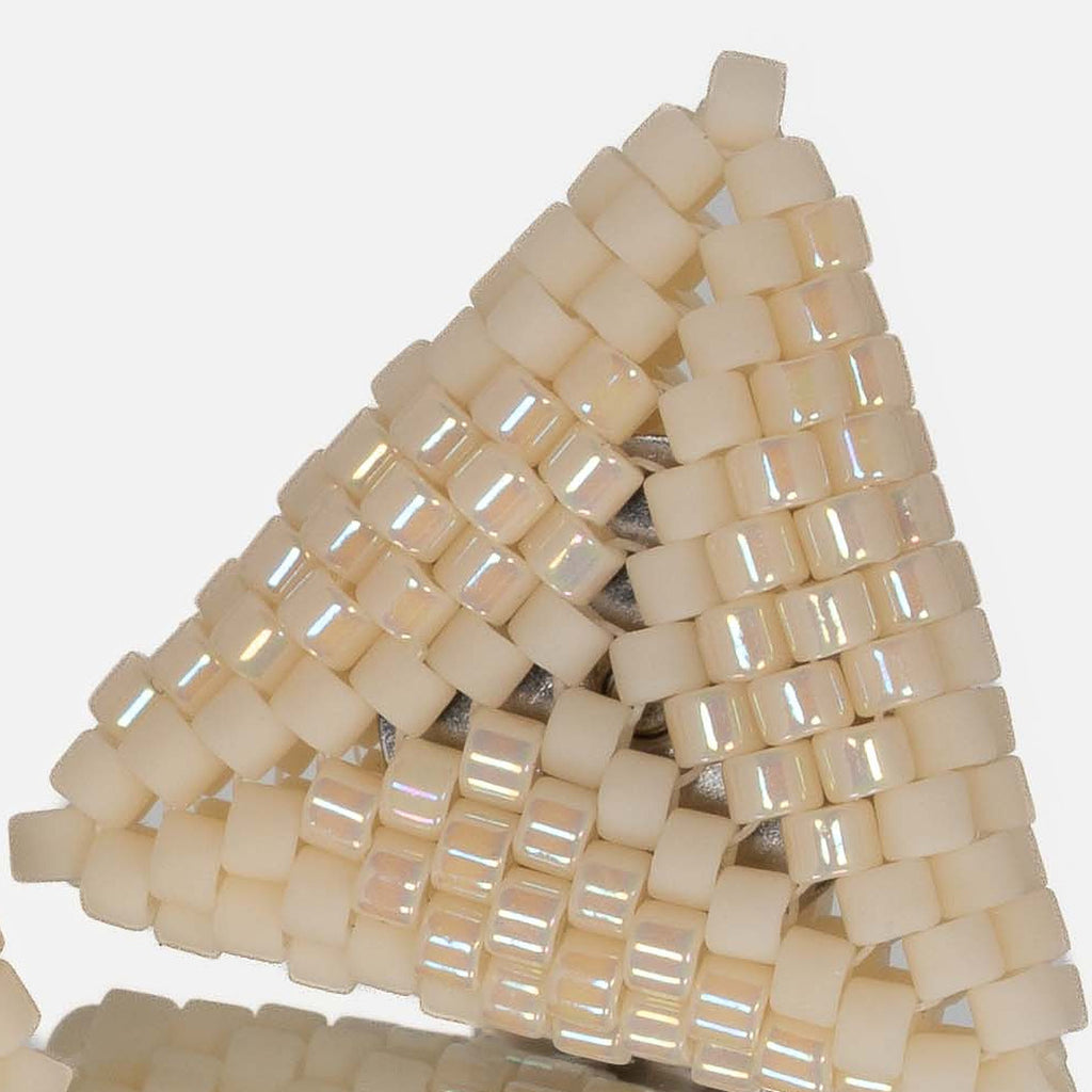 Close-up of matte cream and iridescent cream cylinder beads woven in peyote stitch