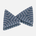 Pair of hand-woven beaded triangle earrings with matte dusty blue and luster denim stripes, standing on a mirror