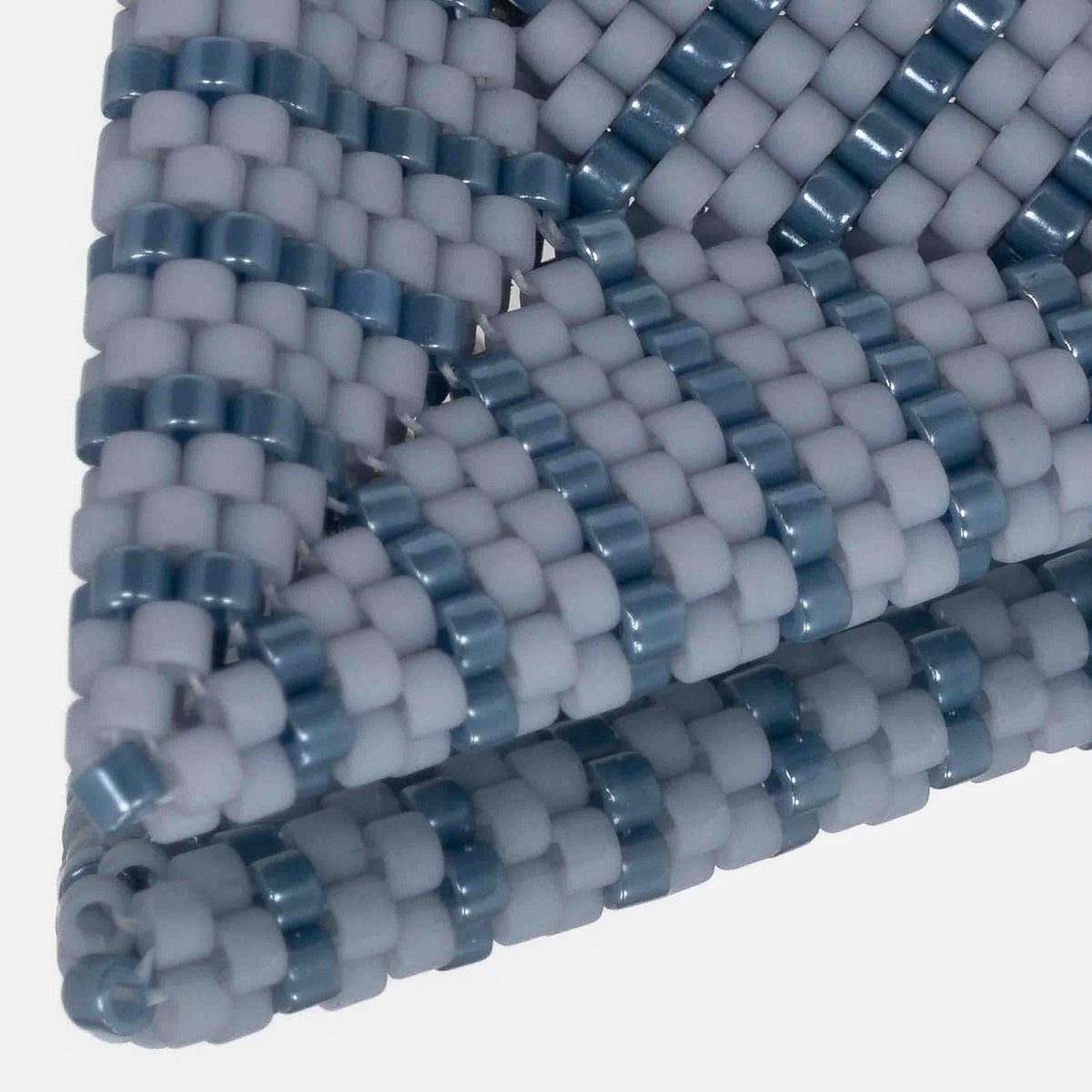 Close-up of matte cream and iridescent cream cylinder beads woven in peyote stitch