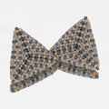 Pair of hand-woven dusty blue, denim, and tan beaded triangle earrings, standing on a mirror