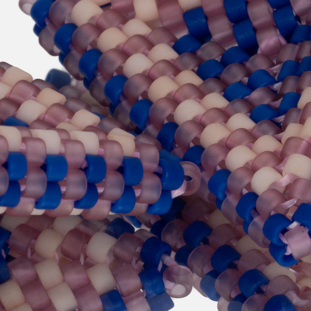 Close-up of frosted lilac, cobalt blue, and matte bone cylinder beads woven in peyote stitch