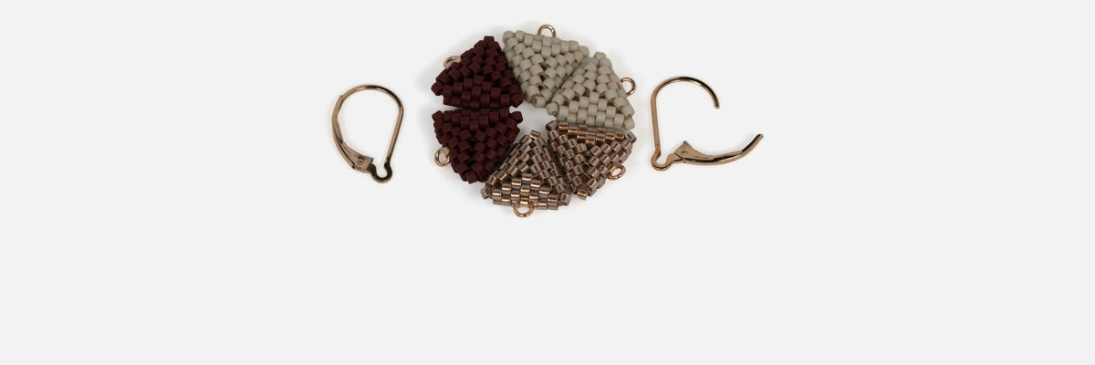 Three pairs of interchangeable beaded triangle modules in oxblood, greige, and antique copper, arranged between two open gold-filled lever-backs.