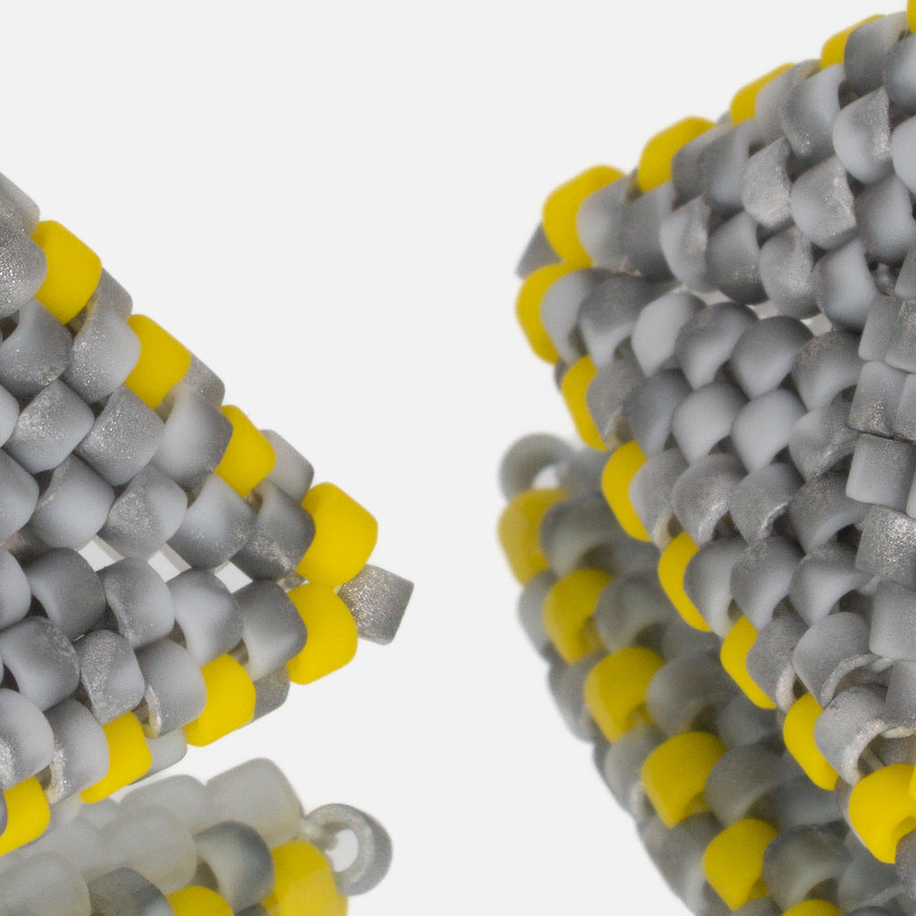 Close-up of matte mottled gray and yellow cylinder beads woven in peyote stitch