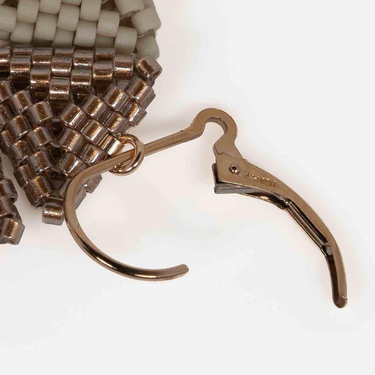 Close-up of a gold-filled interchangeable lever-back, opened to swap a beaded triangle module.