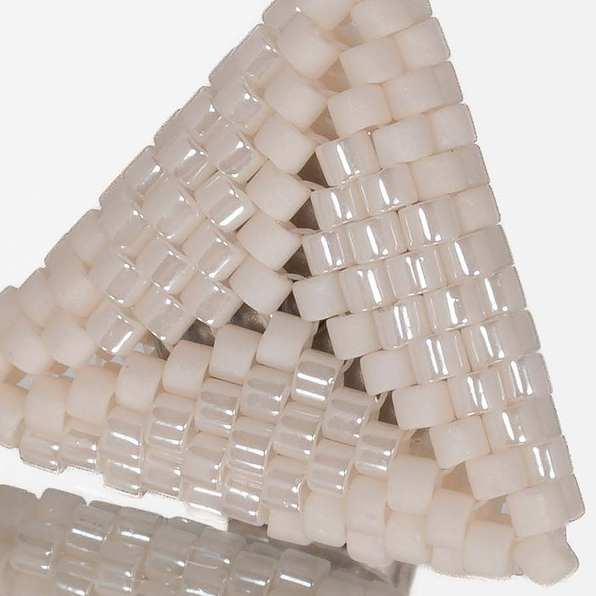 Close-up of matte and pearly ivory cylinder beads woven in peyote stitch