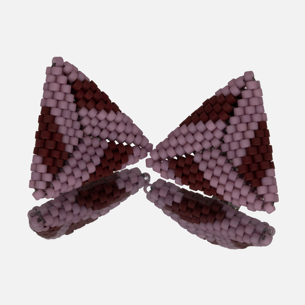 Pair of hand-woven beaded triangle earrings in matte lilac with bands of burgundy, standing on a mirror