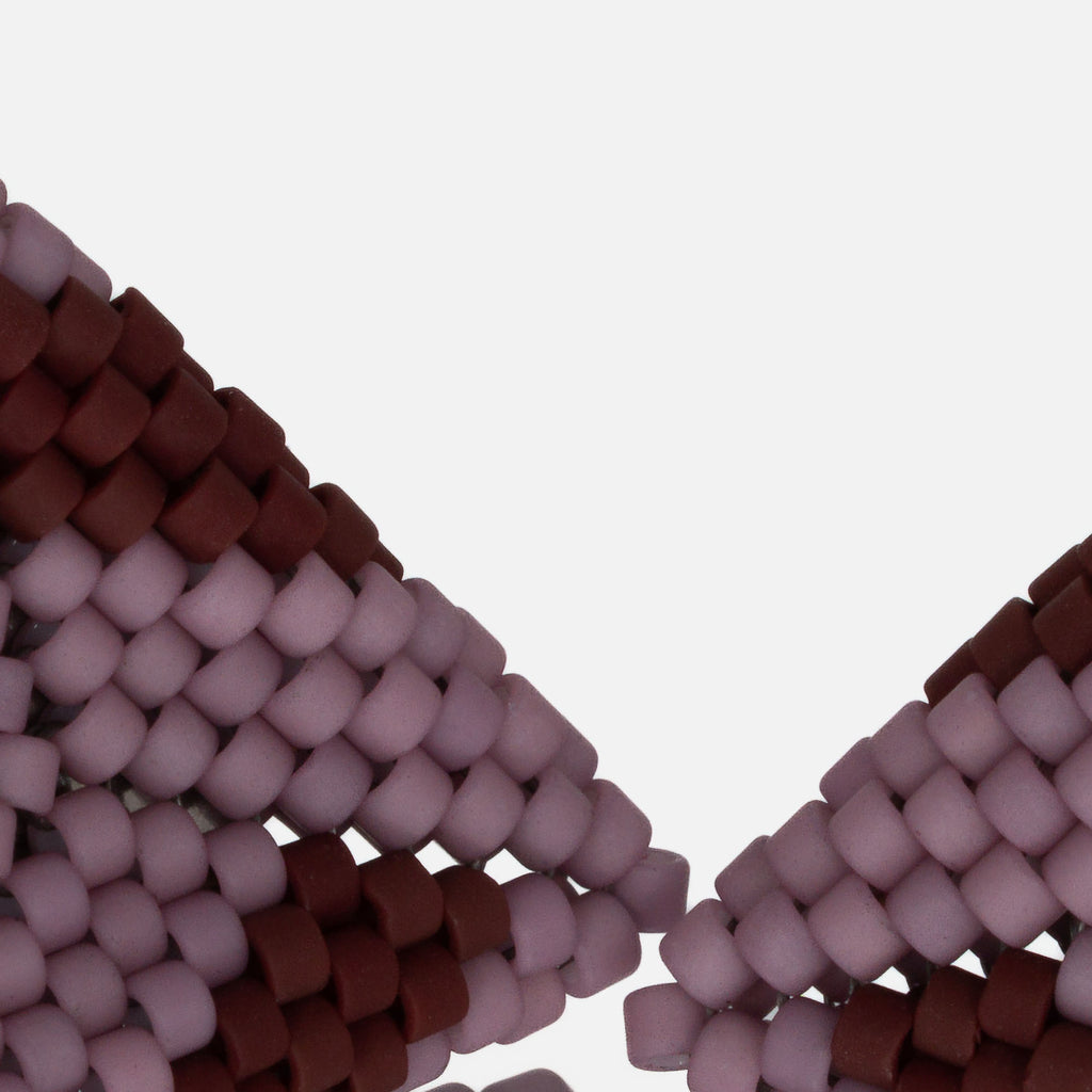 Close-up of matte lilac and burgundy cylinder beads woven in peyote stitch