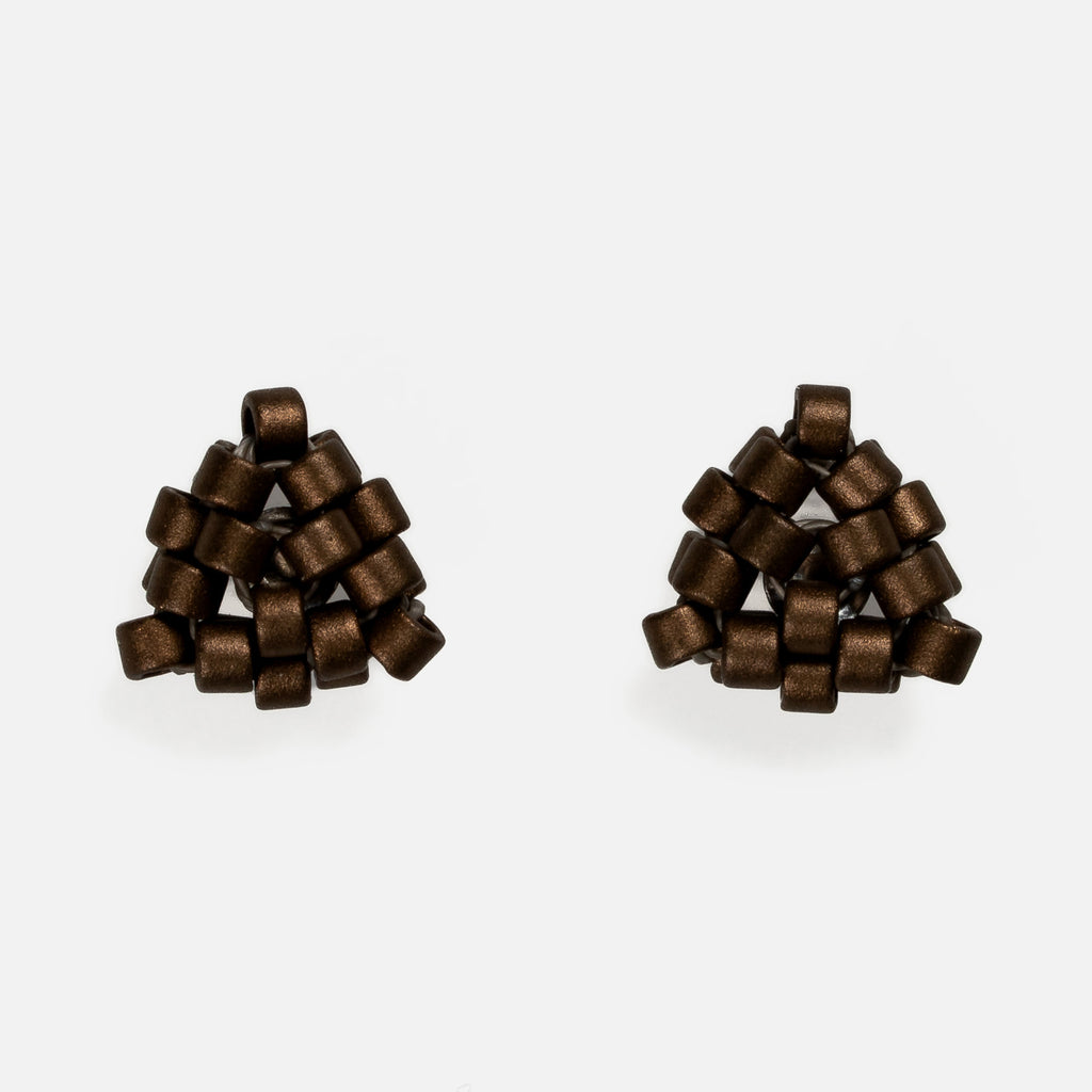Pair of tiny triangular beaded stud earrings in matte metallic bronze with a satin shimmer, front view on a light gray background