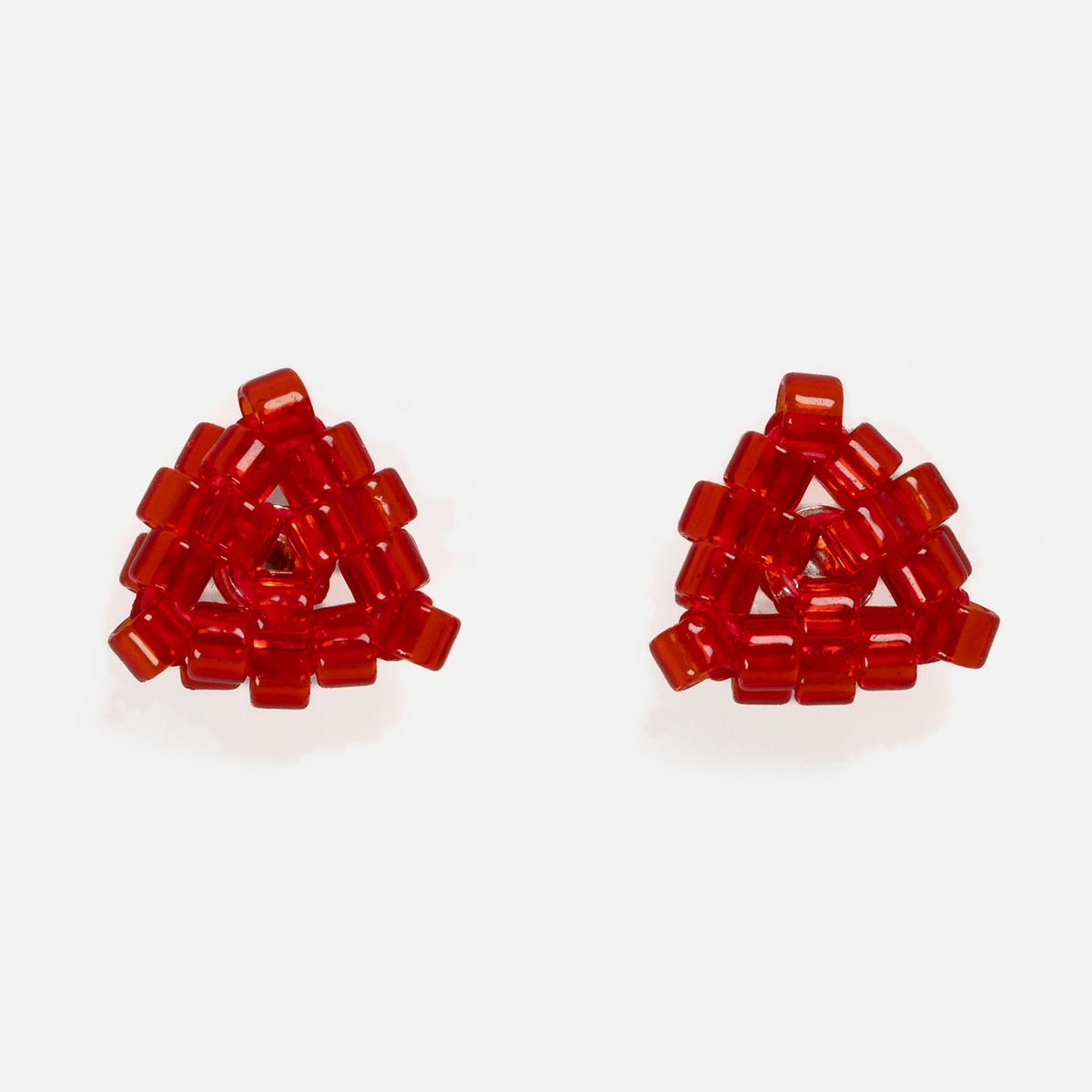 Pair of tiny triangular beaded stud earrings in transparent ruby red glass beads, front view on a light gray background