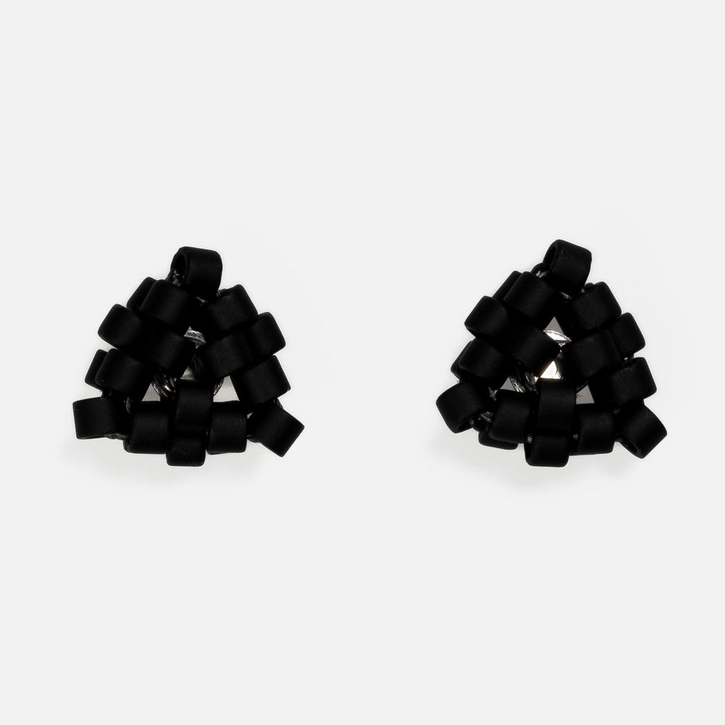 Pair of tiny triangular beaded stud earrings in flat matte black, front view on a light gray background