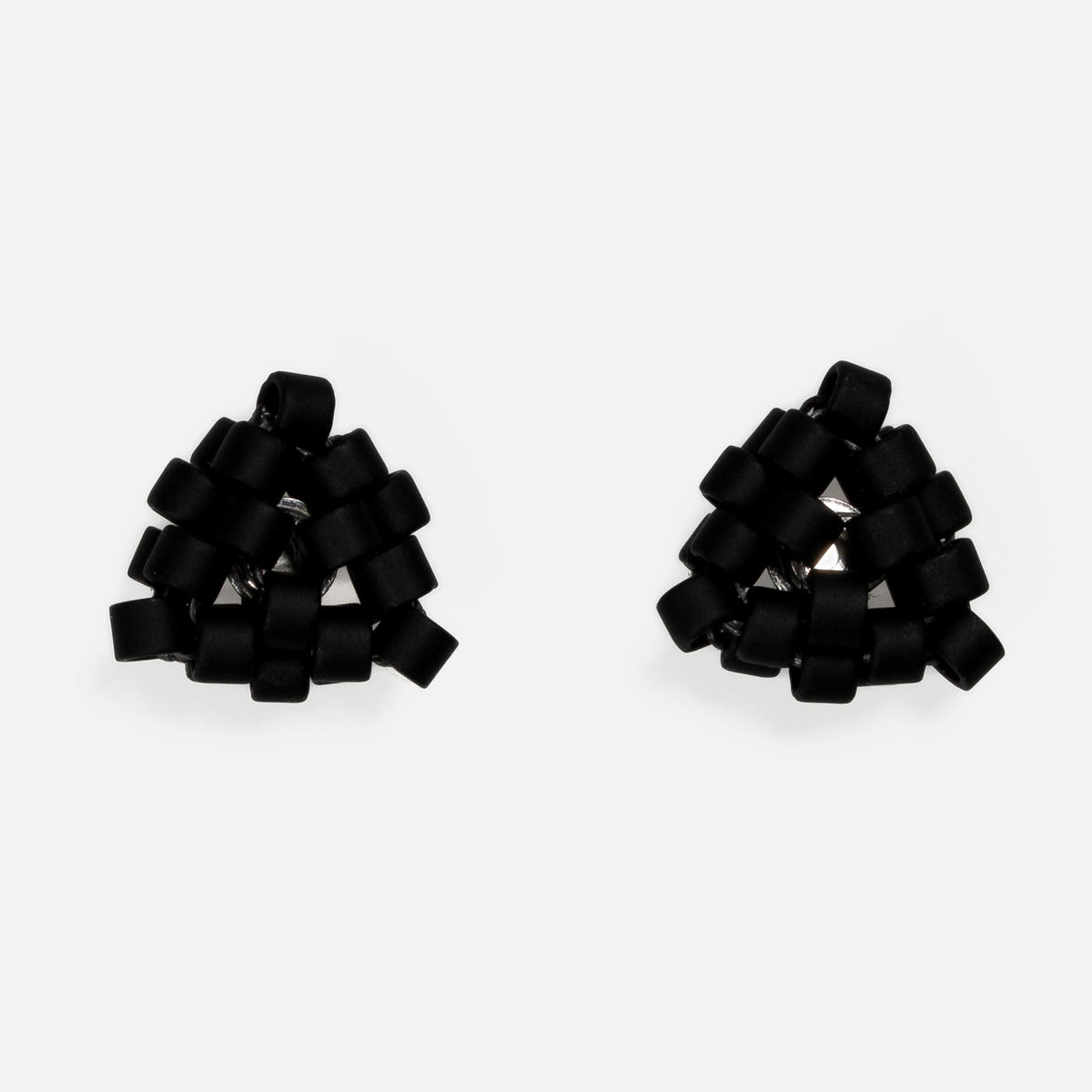 Pair of tiny triangular beaded stud earrings in flat matte black, front view on a light gray background