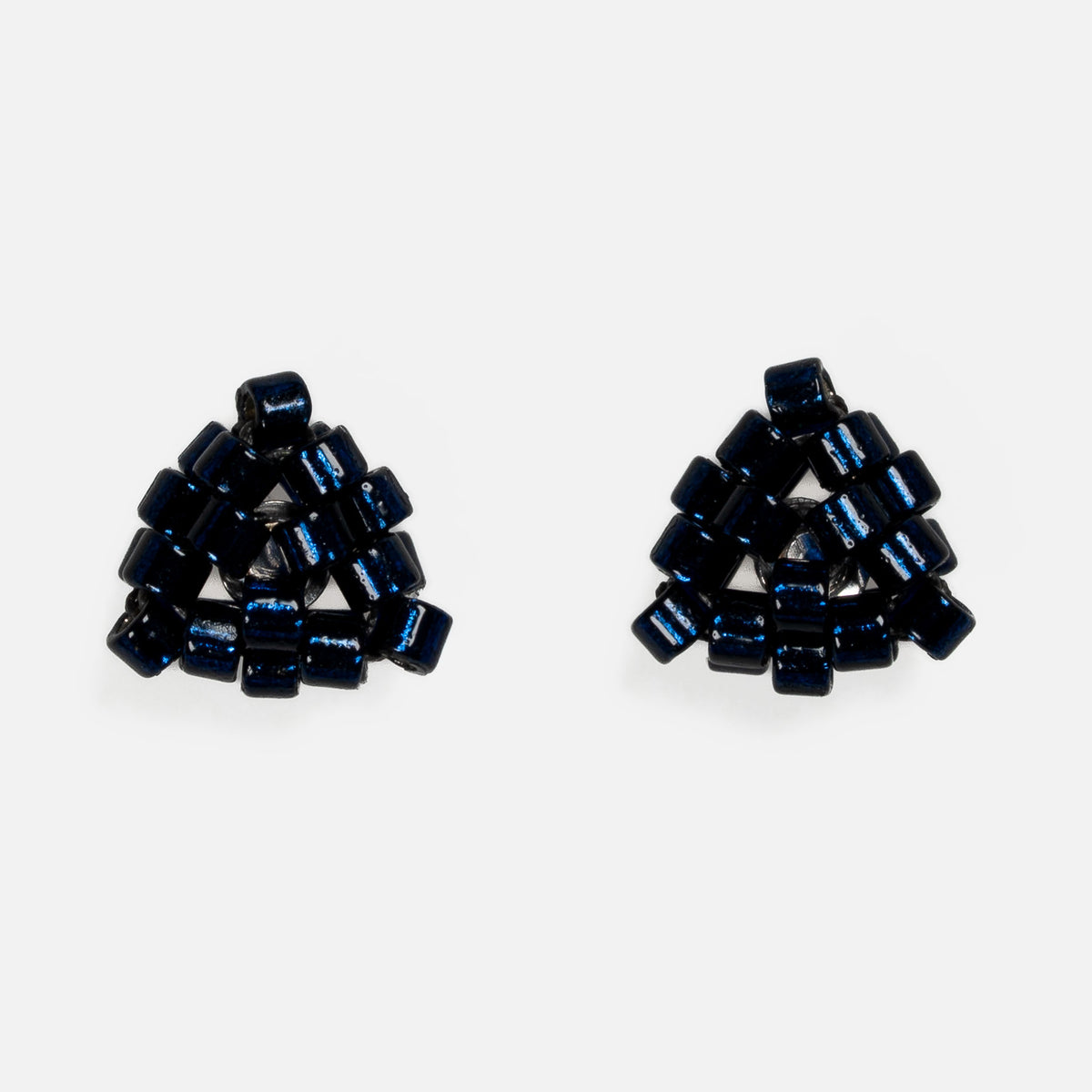 Pair of tiny triangular beaded stud earrings in silver-lined midnight blue, front view on a light gray background