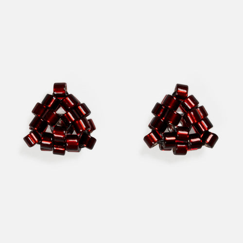 Pair of tiny triangular beaded stud earrings in silver-lined cranberry red, front view on a light gray background