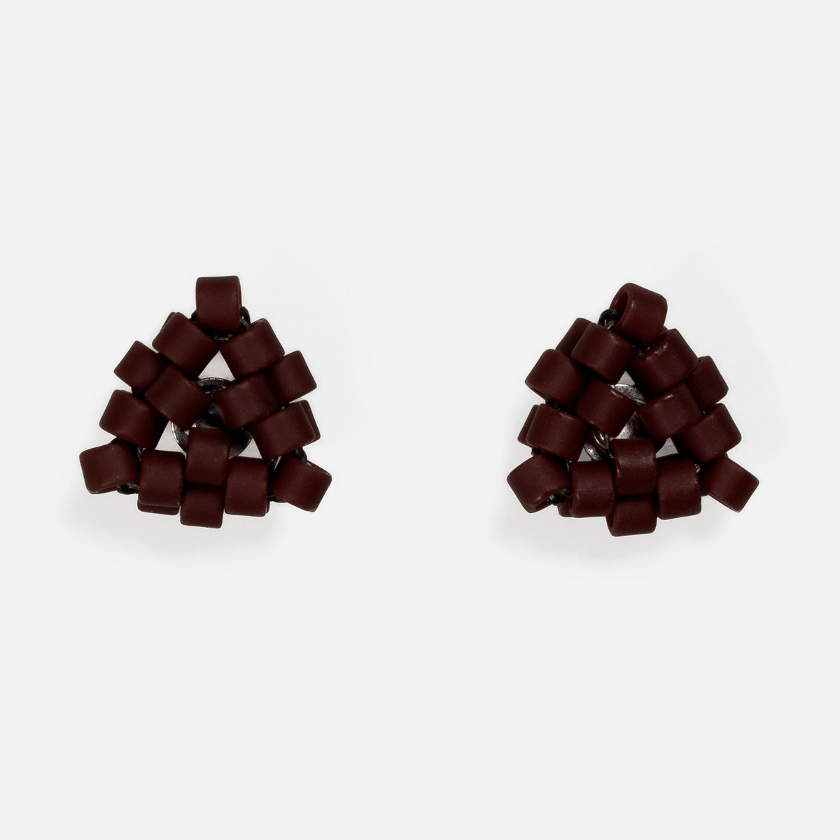 Pair of tiny triangular beaded stud earrings in matte oxblood red, front view on a light gray background