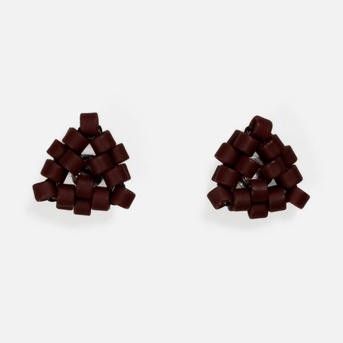 Pair of tiny triangular beaded stud earrings in matte oxblood red, front view on a light gray background