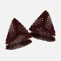 Pair of small hand-woven beaded triangle earrings in matte and luster burgundy, standing on a mirror