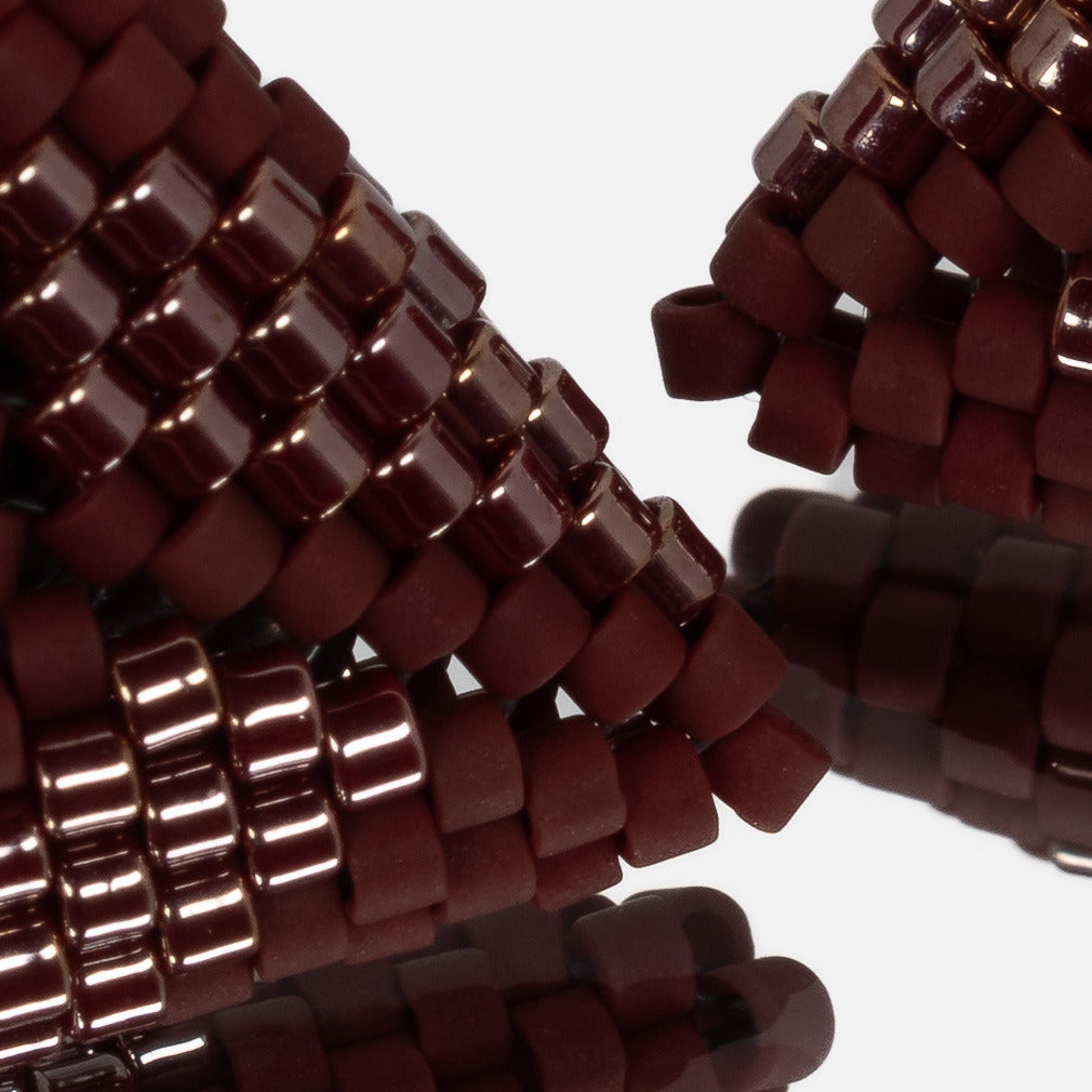 Close-up of matte and luster burgundy cylinder beads woven in peyote stitch