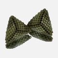 Pair of small hand-woven beaded triangle earrings in matte and luster olive green, standing on a mirror