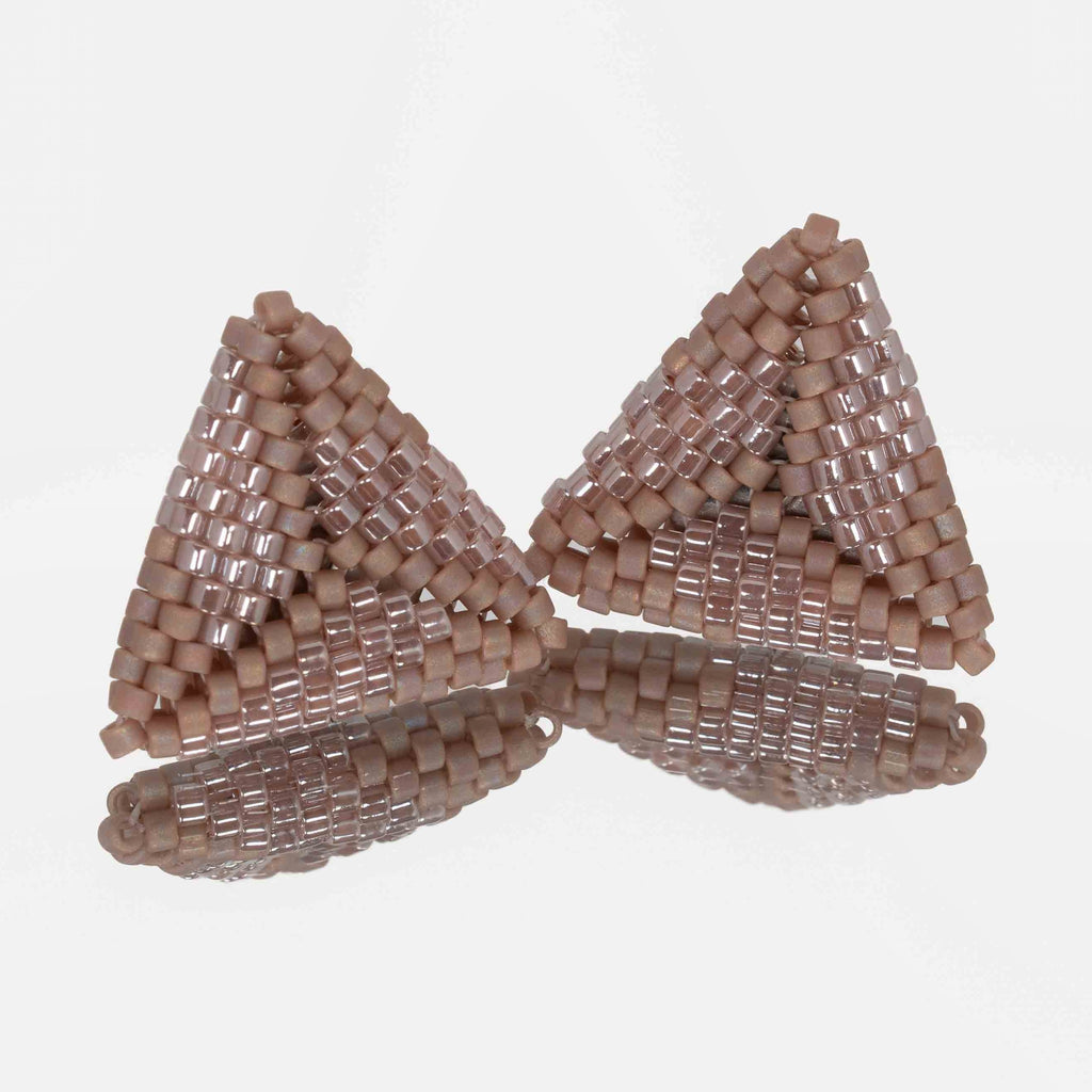 Pair of hand-woven rose taupe beaded triangle earrings, standing on a mirror
