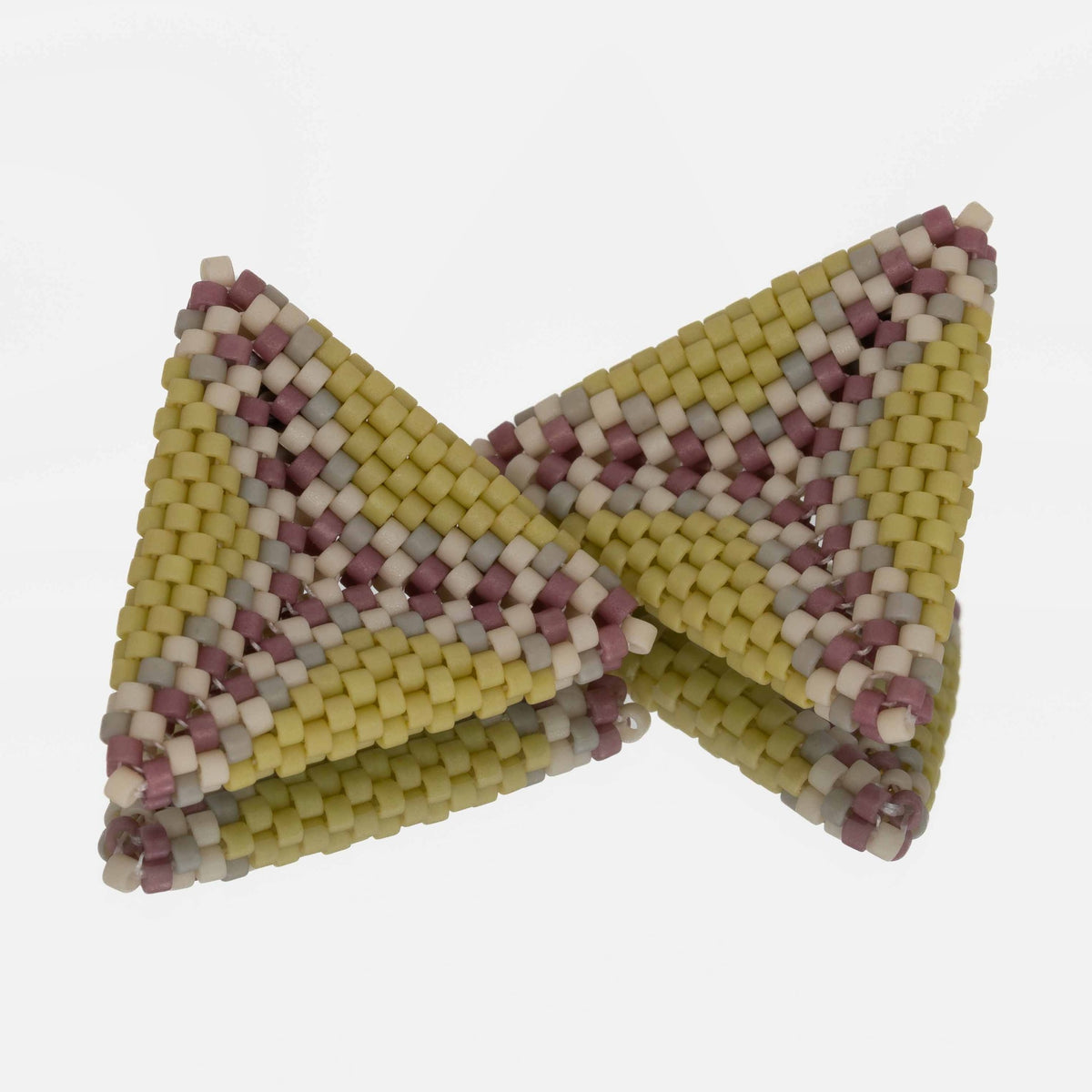 Pair of hand-woven spring green, lilac, and cream beaded triangle earrings, standing on a mirror