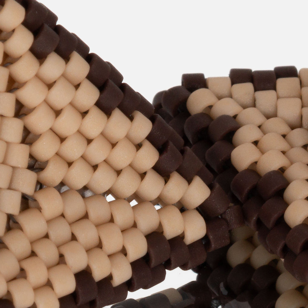 Close-up of matte tan and chocolate brown cylinder beads woven in peyote stitch